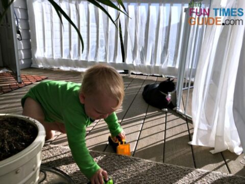 An outdoor rug, potted plant, and long sheer curtains are all an important part of this DIY porch makeover.