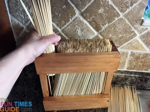 Adding the bamboo skewers to the wooden frame.