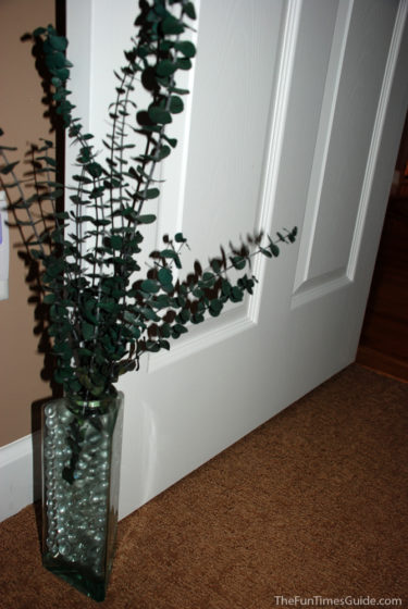 Large, uniquely shaped glass bottles and jars make great door stops! This one is filled with clear decorative marbles and eucalyptus leaves - a natural room deodorizer! 