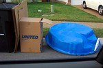 A kiddie pool left in the trash for the garbage men to take away.