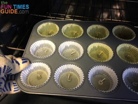 Removing melted wax in cupcake liners from the oven.