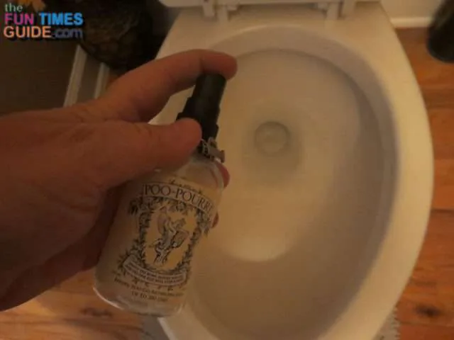 Trying to take a picture of myself spraying Poo Pourri into the toilet bowl - sorry it's so dark.