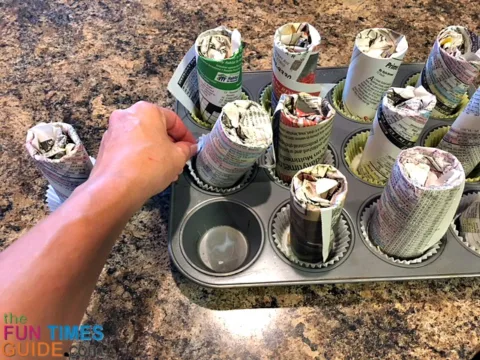 Remove the stuffed cardboard tubes from the cupcake pan by pulling on the cupcake wrapper (to keep the wicks in place).