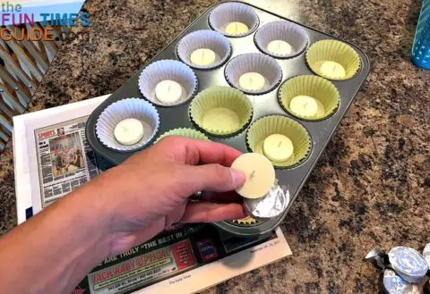 Removing the tealight candles from their tin liners, and putting the candles into cupcake liners.