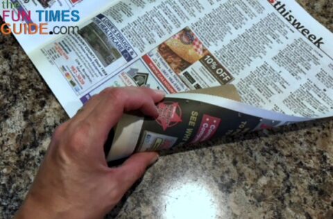 Rolling a tube stuffed with dryer lint in a sheet of newspaper.