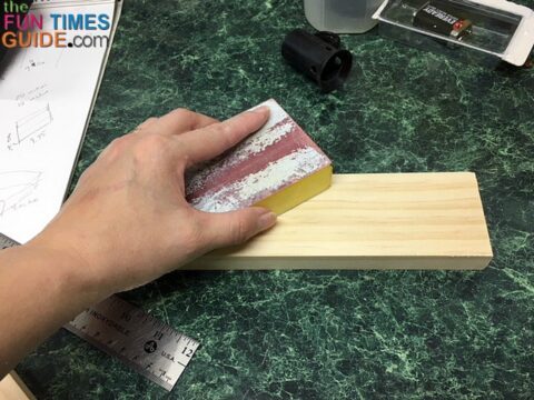 Using a sanding block to smooth rough edges.