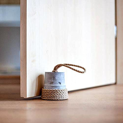 A simple but rustic DIY door stop is to use an empty tin can or bucket filled with something heavy and decorated with fabric rope -- like jute or hemp.