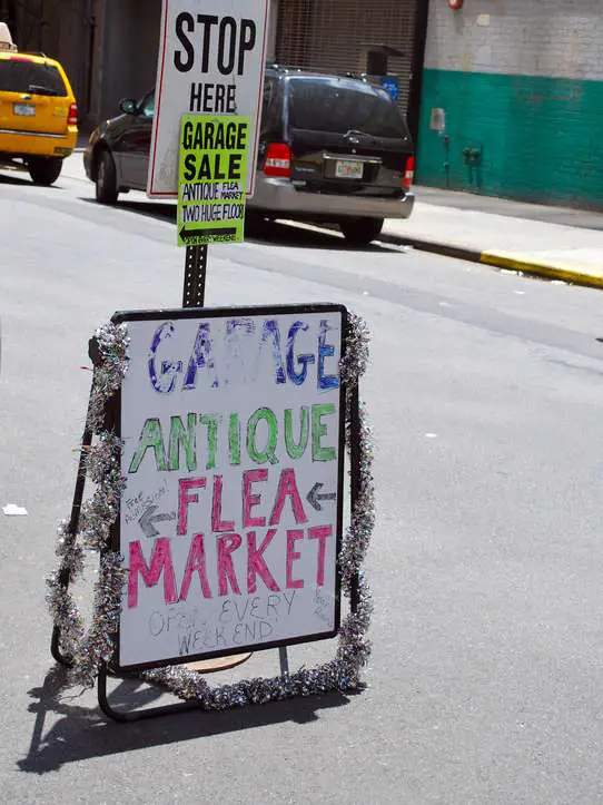 Here's a write-on wipe-off style of sandwich board being used as a yard sale sign -- with tinsel garland that will attract extra attention in the breeze! 