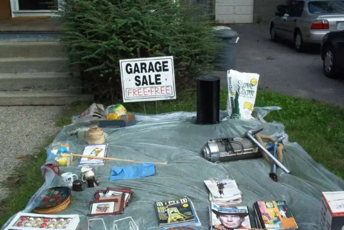 Freebies at the yard sale organized on a blanket with a FREE sign. 