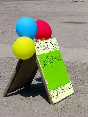 An example of an old wooden sandwich board being used as a yard sale sign -- with attention getting balloons! 